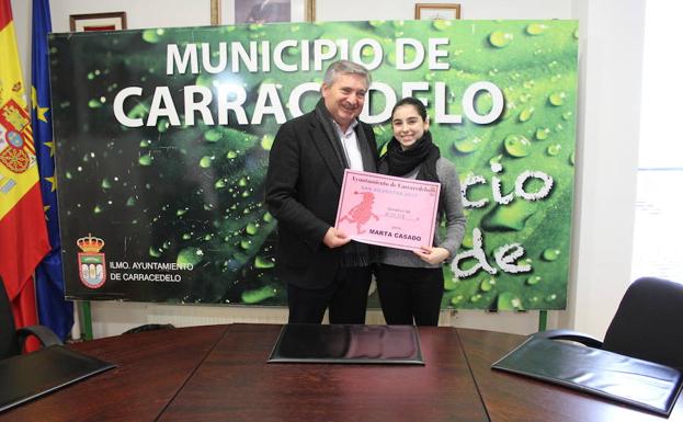El alcalde de Carracedelo, Raúl Valcarce, entrega el cheque de la San Silvestre a la deportista Marta Casado./