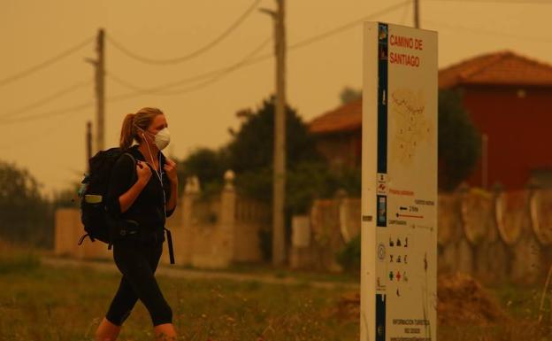 Una peregrina se tapa la cara debido al intenso humo existente en Ponferrada/ ical