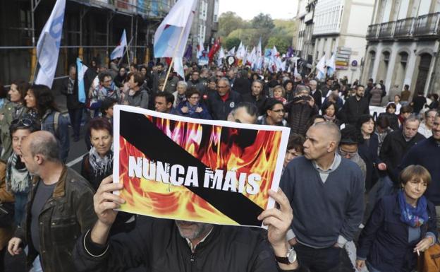 Un hombre porta un cartel con el lema 'Nunca mais', durante la concentración./Efe