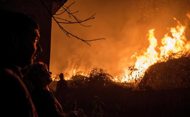 Varias personas observan uno de los incendios en Galicia. /Efe