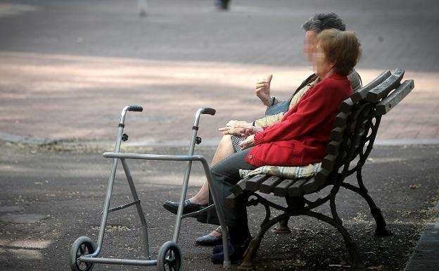 Dos ancianas descansan en un banco del jardín de una residencia geriátrica./B. Agudo