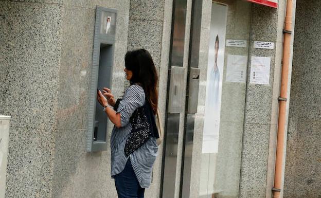 Una mujer utiliza un cajero automático. /Albert Gea (Reuters)