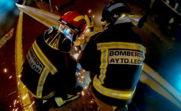 Dos efectivos de Bomberos cortando el guardarraíl. /Bomberos León