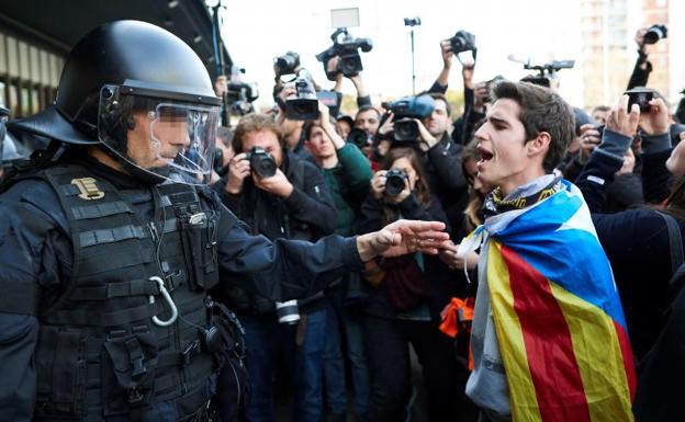 Un joven con una estelada ante un agente de los Mossos./Alejandro García (Efe)