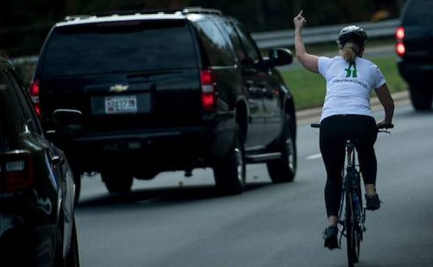 Juli Briskman hace un gesto con el dedo corazón al pasar un coche con Donald Trump. /Brendan Smialowski (AFP)