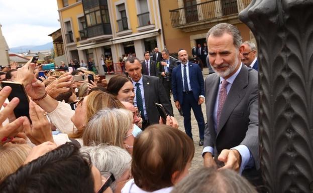 El rey Felipe VI saluda a los ponferradinos en la plaza del Ayuntamiento de Ponferrada con la panadería Liébana al fondo.