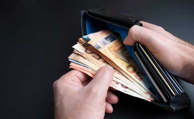 Imagen de una cartera con dinero en su interior./