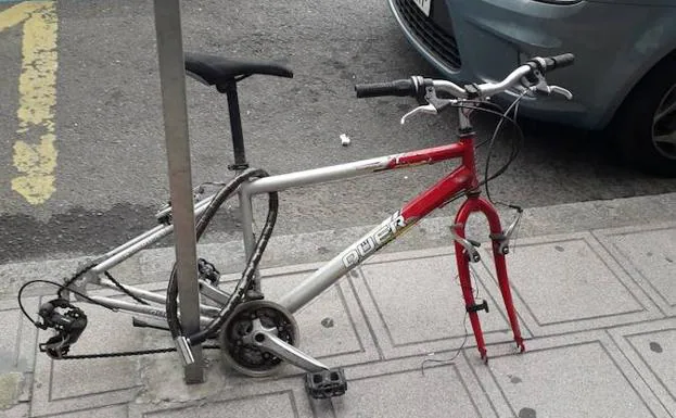 Bicicleta, a la que le han desvalijado las ruedas, en plena avenida Padre Isla. /