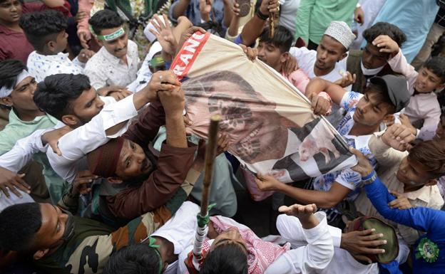 Francia multiplica la seguridad antiterrorista 1 Un grupo de musulmanes destruye un cartel con el rostro de Macron en un pueblo de India.