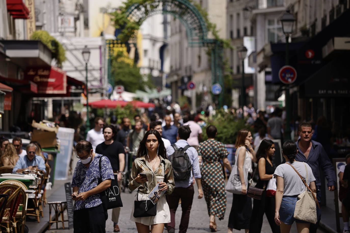 Los ciudadanos caminan sin mascarilla por las calles de París./EFE