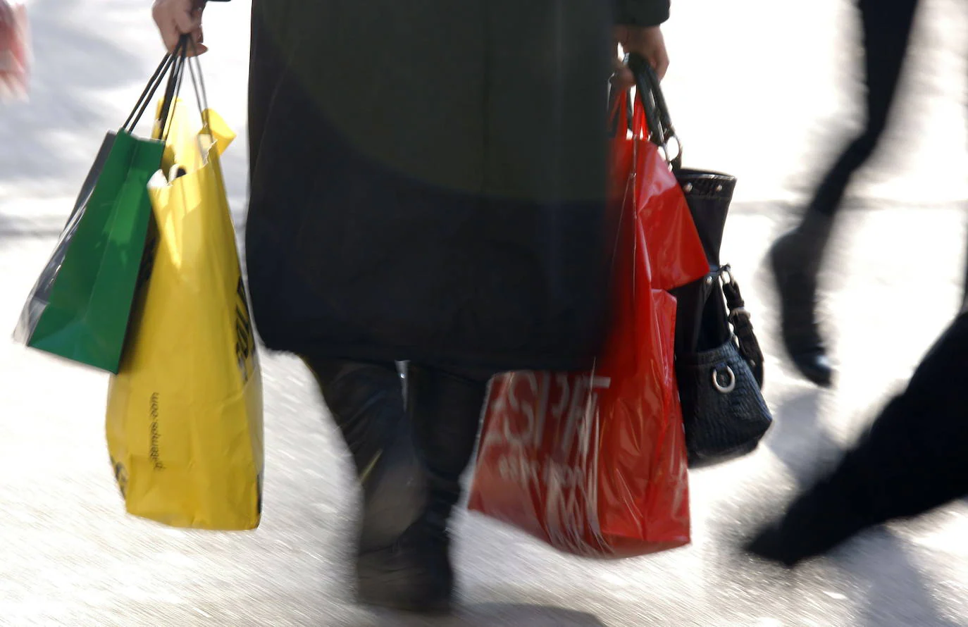 Una señora pasea con bolsas de la compra. /reuters