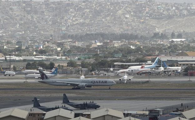 Un avión comercial se dispone a despegar ayer de Kabul junto a dos aernonaves militares de Estados Unidos./AFP