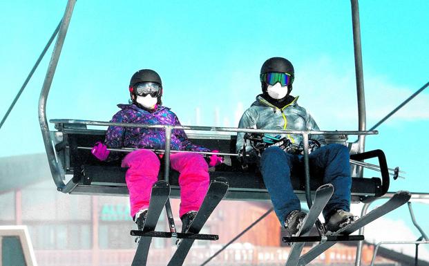 Esquiadores con mascarilla ascienden en el telesilla a las pistas de Sierra Nevada, uno de los destinos preferidos en España para los amantes de la nieve. /EUROPA PRESS
