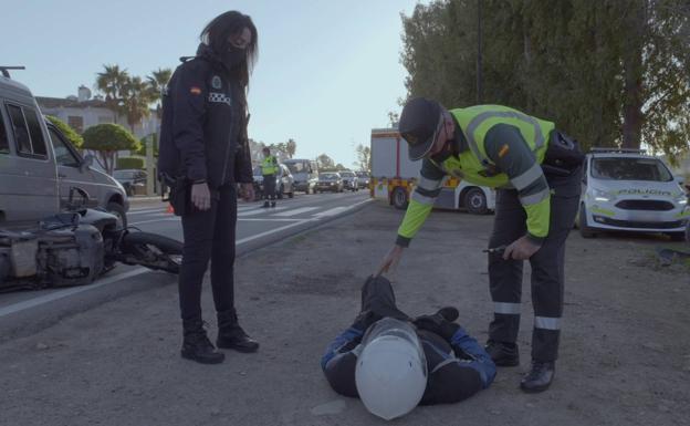 Un guardia civil y una agente municipal atienden a un motorista herido. /r. c.