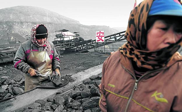 Mineros chinos cargan carbón en una cinta transportadora de la localidad de Datong/AFP