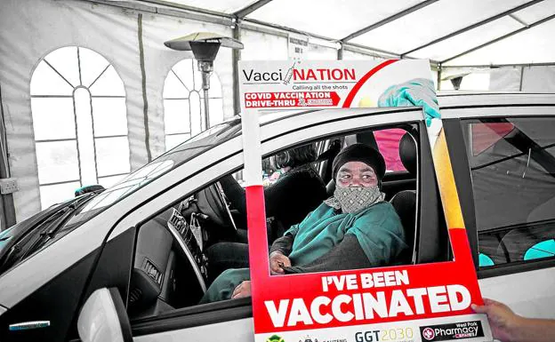 Una mujer acaba de ser inmunizada sin bajarse del coche en Pretoria, la ciudad más poblada de Sudáfrica, donde se ha vacunado ya el 24% de la población.