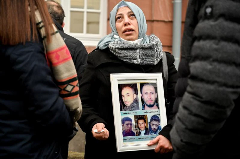 Ein syrischer Flüchtling zeigt vor dem Gericht in der Stadt Koblenz Fotos der Opfer. 