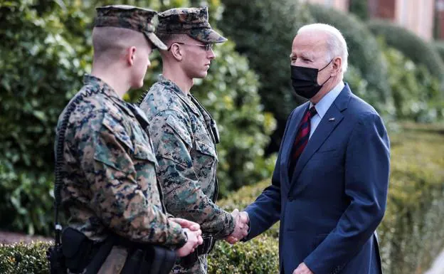 Joe Biden saluda a dos militares. /Efe