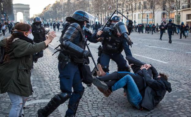 Agentes franceses cargan contra unos jóvenes manifestantes en los Campos Elíseos./EFE