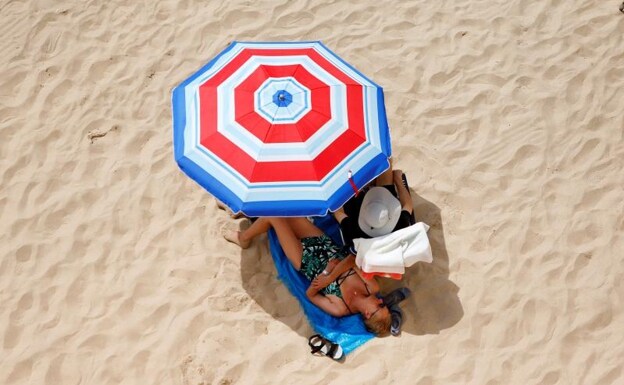 Dos turistas toman el sol en las playas del Mediterráneo./EFE